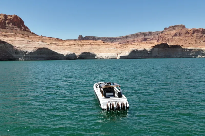 Slide: The Image of 2024 Cigarette 42' Auroris boat on scenic lake with rocky cliffs. - 11