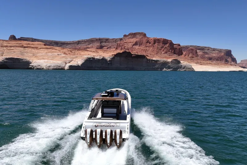 Slide: The Image of 2024 Cigarette 42' Auroris speedboat cruising on a scenic lake with rocky cliffs. - 15
