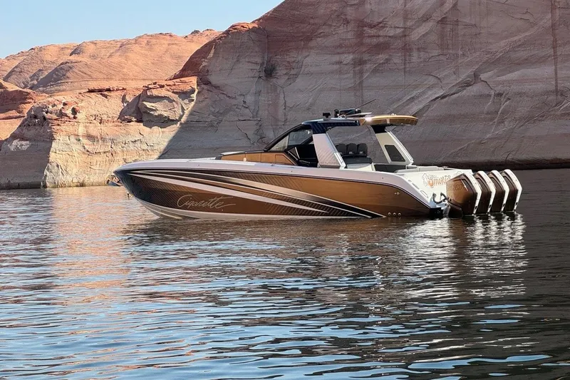 Slide: The Image of 2024 Cigarette 42' Auroris boat on water, with rocky cliffs in the background. - 2