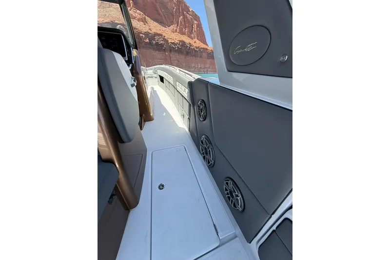 Slide: The Image of 2024 Cigarette 42' Auroris boat interior with speakers, against a canyon backdrop. - 25