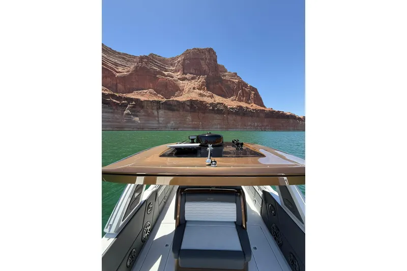Slide: The Image of 2024 Cigarette 42' Auroris boat cruising on a lake with scenic rocky cliffs. - 26