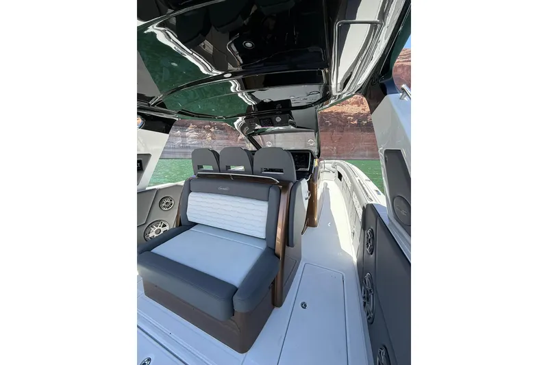 Slide: The Image of 2024 Cigarette 42' Auroris boat interior with sleek seating and modern design on a scenic waterway. - 28
