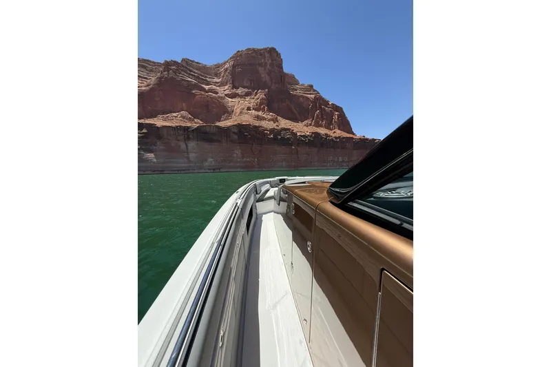 Slide: The Image of 2024 Cigarette 42' Auroris boat cruising near red rock cliffs under clear blue sky. - 40