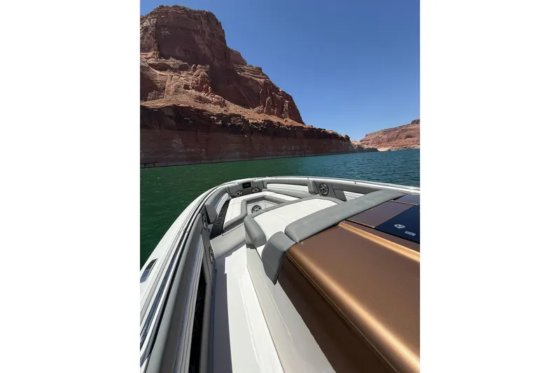 Slide: The Image of 2024 Cigarette 42' Auroris boat cruising near red rock cliffs on a sunny day. - 42