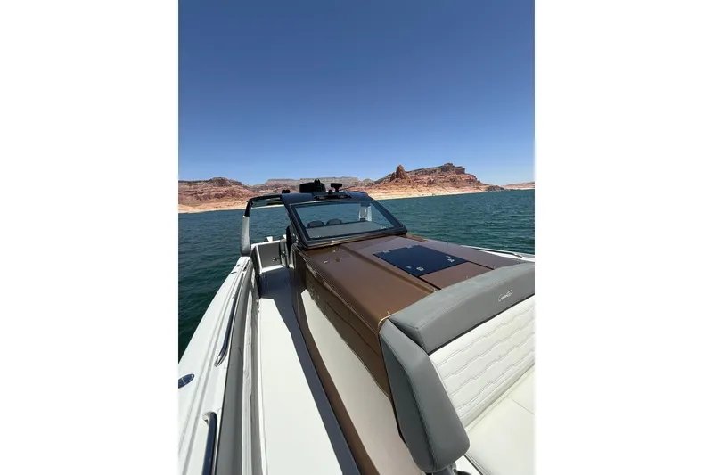 Slide: The Image of 2024 Cigarette 42' Auroris boat cruising on a scenic lake with rocky cliffs. - 49