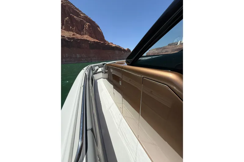 Slide: The Image of 2024 Cigarette 42' Auroris boat cruising near rocky cliffs under clear blue sky. - 55