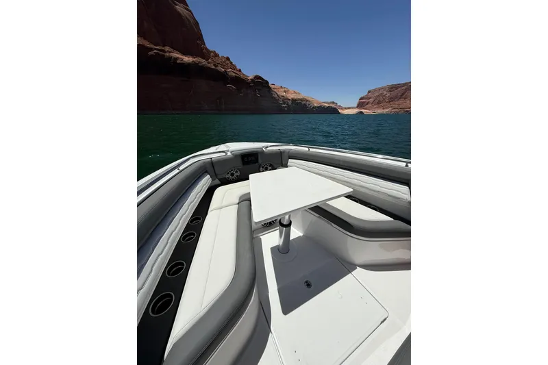 Slide: The Image of 2024 Cigarette 42' Auroris boat interior with seating and table on a scenic lake. - 65