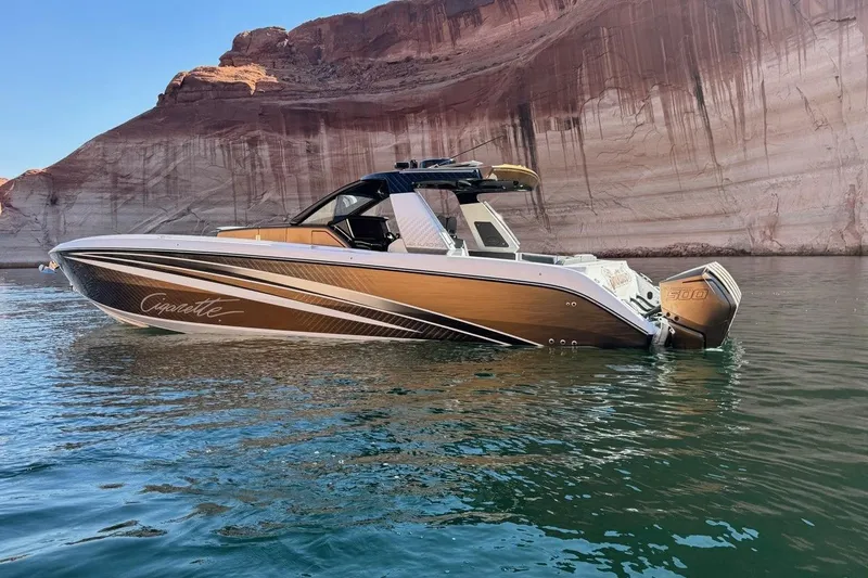 Slide: The Image of 2024 Cigarette 42' Auroris boat on water, scenic canyon backdrop. - 7