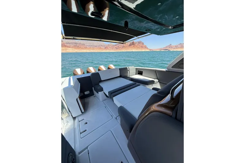 Slide: The Image of 2024 Cigarette 42' Auroris boat interior with luxurious seating, overlooking scenic water and cliffs. - 70