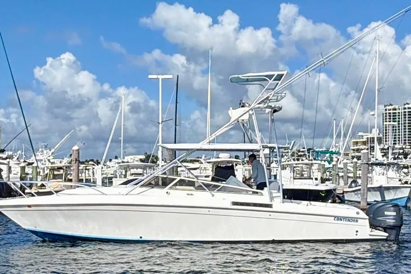 The Image of 2000 Contender 35 Side Console boat docked at marina under blue sky. - 1