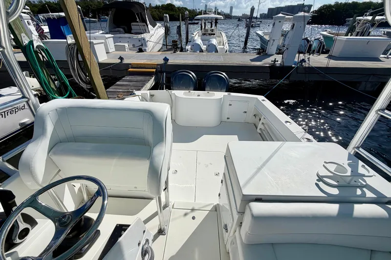 Slide: The Image of 2000 Contender 35 Side Console boat interior at marina, featuring seating and steering wheel. - 14