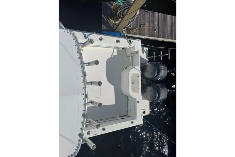 Slide: The Image of 2000 Contender 35 Side Console boat with dual outboard motors docked at a pier. - 17
