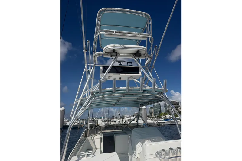 Slide: The Image of 2000 Contender 35 Side Console boat with tower, docked under clear blue sky. - 19