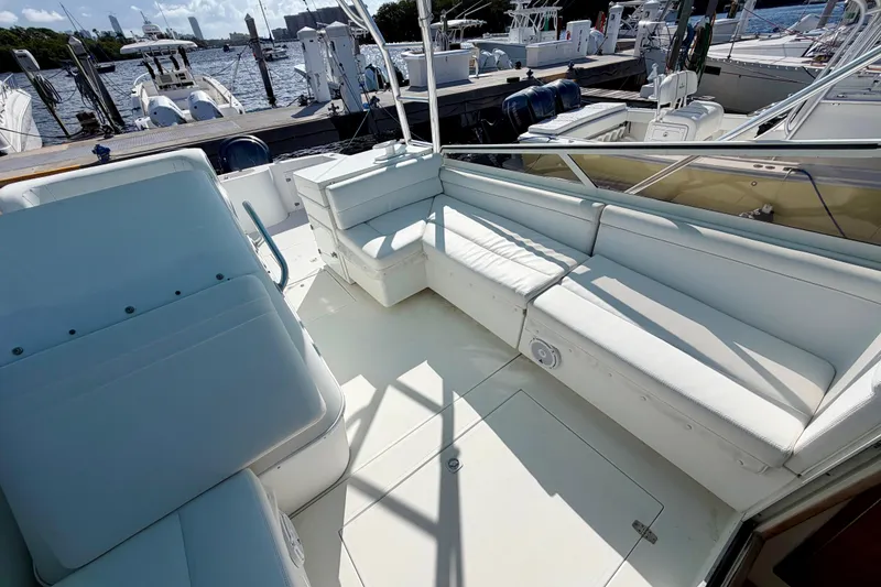 Slide: The Image of 2000 Contender 35 Side Console boat with spacious white seating at a marina. - 6