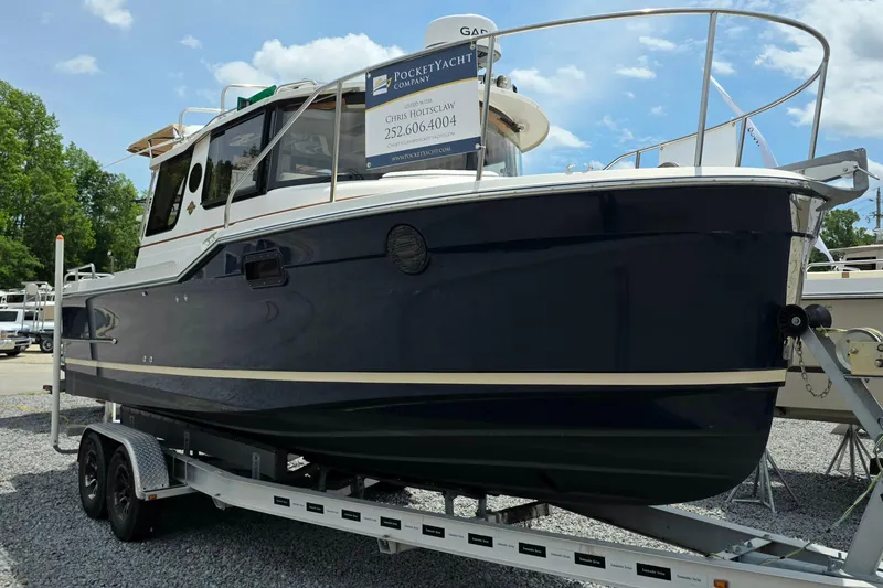 The Image of 2021 Ranger Tugs R-23 boat on trailer, displayed outdoors under a partly cloudy sky. - 0