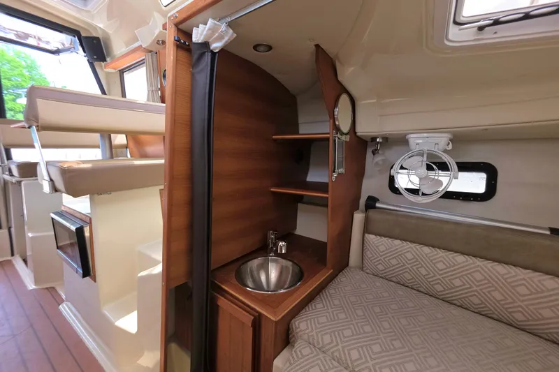 Slide: The Image of Interior of 2021 Ranger Tugs R-23 boat with sink, seating, and wooden cabinetry. - 12