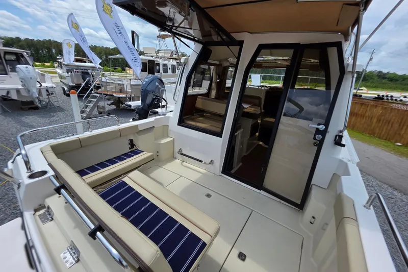 Slide: The Image of 2021 Ranger Tugs R-23 boat interior with seating and open cabin door. - 2