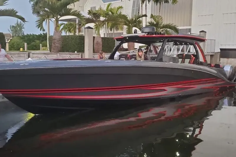 Slide: The Image of 2021 Concept 44' Open Deck boat with sleek black and red design, docked near palm trees. - 16