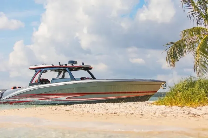 Slide: The Image of 2021 Concept 44' Open Deck boat on sandy beach with palm tree and cloudy sky. - 60