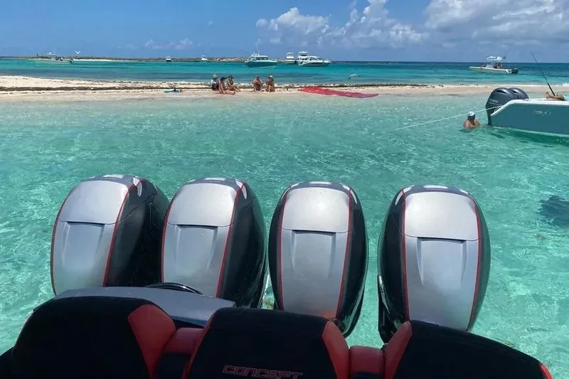 Slide: The Image of Four powerful outboard motors on a 2021 Concept 44' Open Deck boat in clear turquoise water. - 8