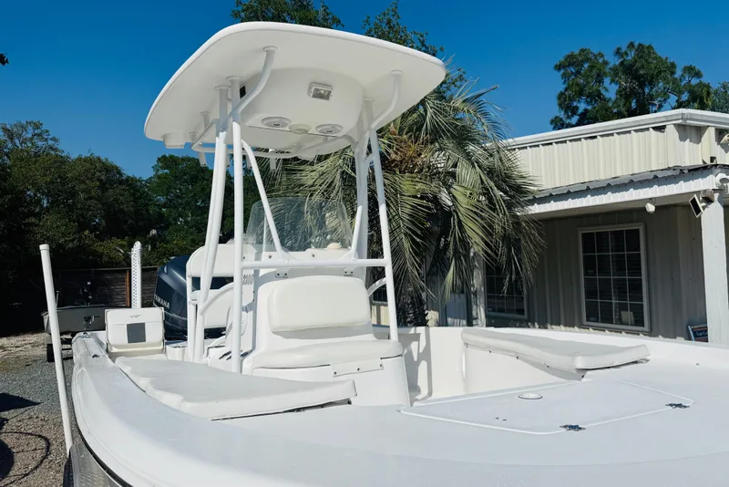 Slide: The Image of 2012 Tidewater 2200 Carolina Bay boat with T-top, parked near a building. - 5