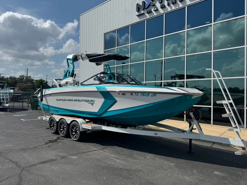 The Image of 2019 Nautique G25 boat in front of a modern building. - 1