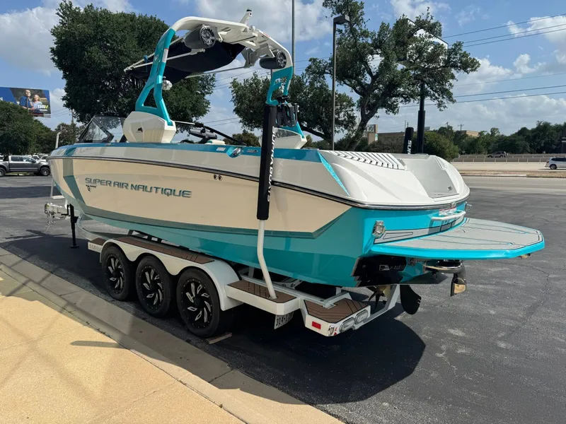 Slide: The Image of 2019 Nautique G25 boat on trailer, blue and white, parked on asphalt. - 5