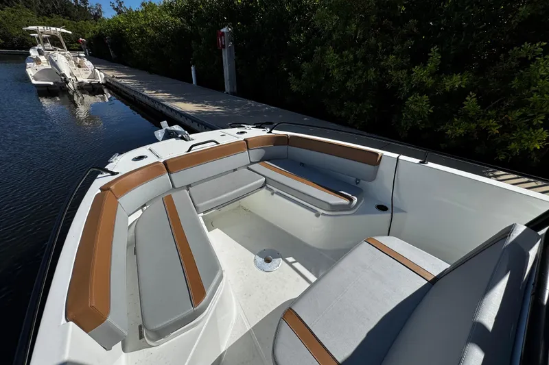 Slide: The Image of 2024 Beneteau Flyer 8 SPACEdeck boat with spacious seating area docked by greenery. - 6