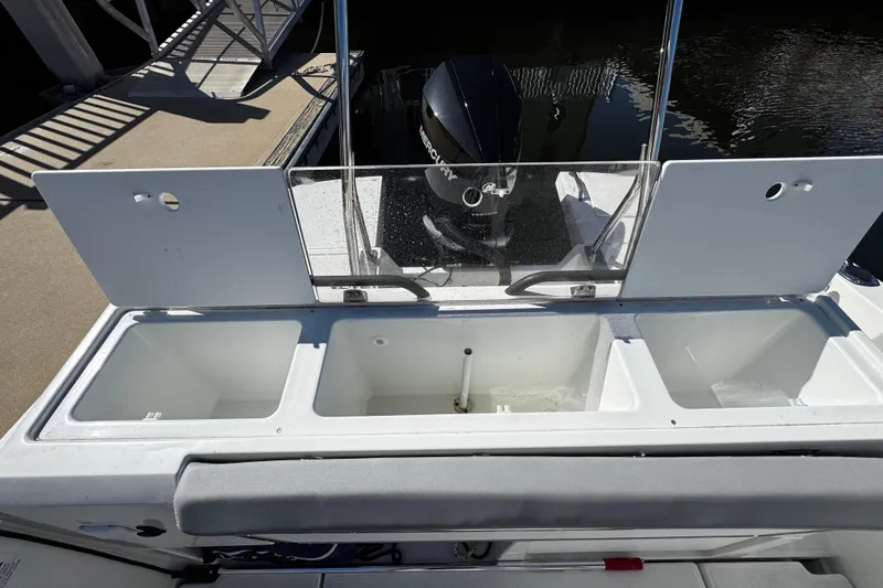 Slide: The Image of 2024 Beneteau Flyer 8 SPACEdeck boat with open storage compartments and motor at dock. - 7