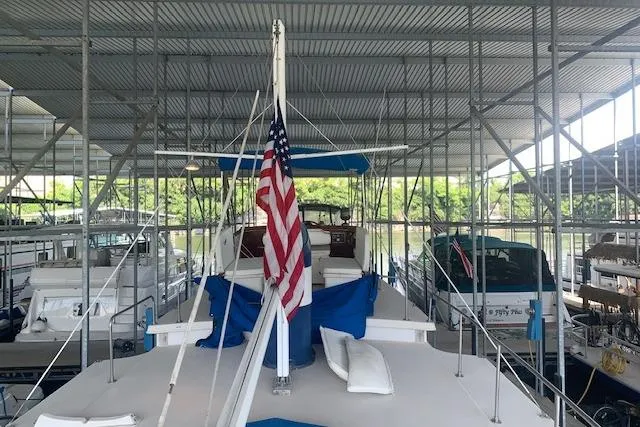 Slide: The Image of 1986 Pilgrim 40 boat docked under a covered marina with American flag. - 10