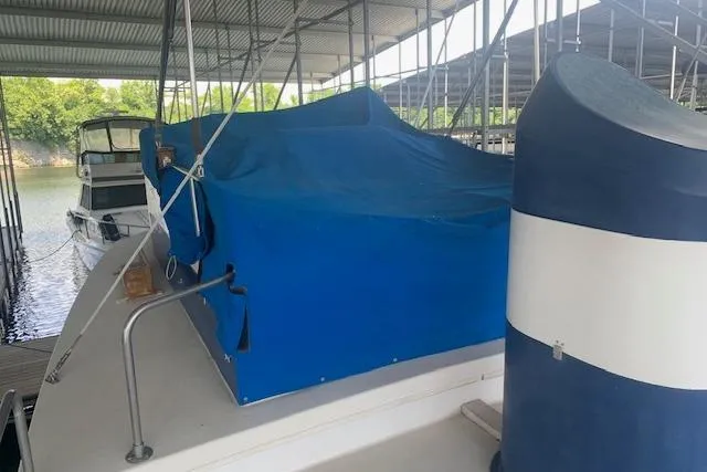 Slide: The Image of 1986 Pilgrim 40 boat docked under a covered marina with blue tarp. - 11