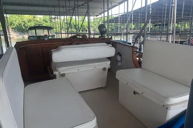 Slide: The Image of 1986 Pilgrim 40 boat interior with white seating, docked under a covered marina. - 12