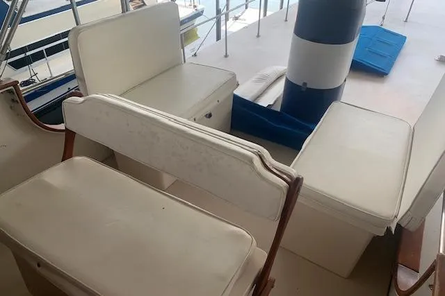 Slide: The Image of 1986 Pilgrim 40 boat interior with white cushioned seating and nautical decor. - 13