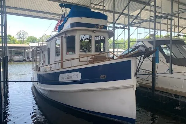 Slide: The Image of 1986 Pilgrim 40 boat docked in a marina, featuring a blue and white exterior. - 2