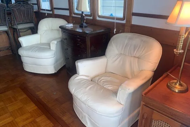 Slide: The Image of Luxurious interior of a 1986 Pilgrim 40 yacht with plush white armchairs and elegant wooden furniture. - 21