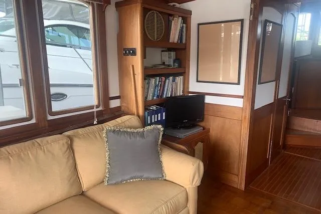 Slide: The Image of Cozy interior of 1986 Pilgrim 40 boat with sofa, bookshelf, and small TV. - 22