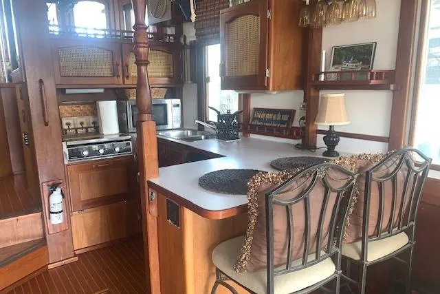 Slide: The Image of Cozy kitchen interior of 1986 Pilgrim 40 boat with wooden cabinetry and bar seating. - 23