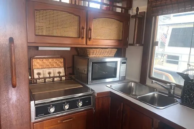 Slide: The Image of 1986 Pilgrim 40 boat kitchen with stove, microwave, and dual sink. - 24