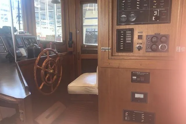 Slide: The Image of 1986 Pilgrim 40 boat interior with wooden helm and control panel. - 31