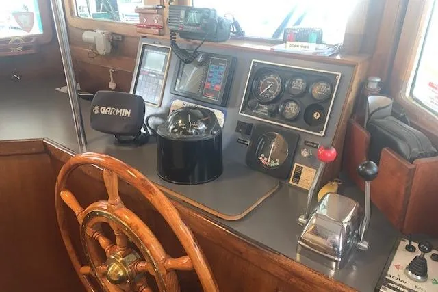 Slide: The Image of Pilgrim 40 boat helm from 1986 with navigation instruments and wooden steering wheel. - 33