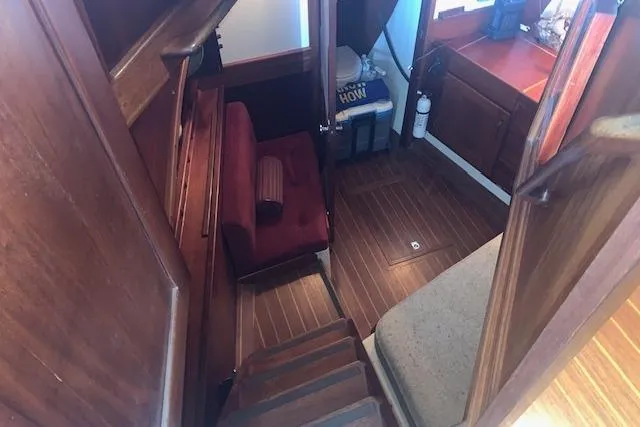Slide: The Image of Interior of a 1986 Pilgrim 40 boat with wooden flooring and seating area. - 35