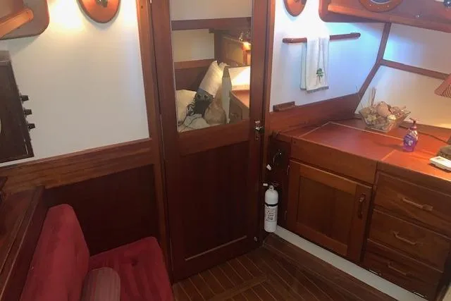 Slide: The Image of Interior of a 1986 Pilgrim 40 boat with wooden cabinetry and cozy seating. - 36