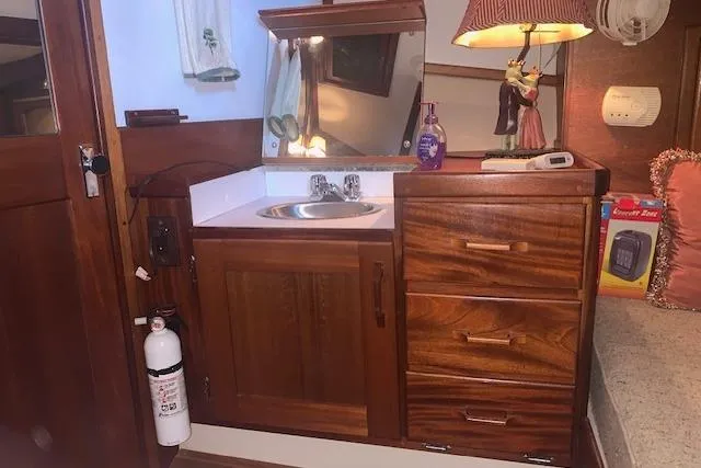 Slide: The Image of 1986 Pilgrim 40 boat interior with wooden cabinetry, sink, and decorative lamp. - 38