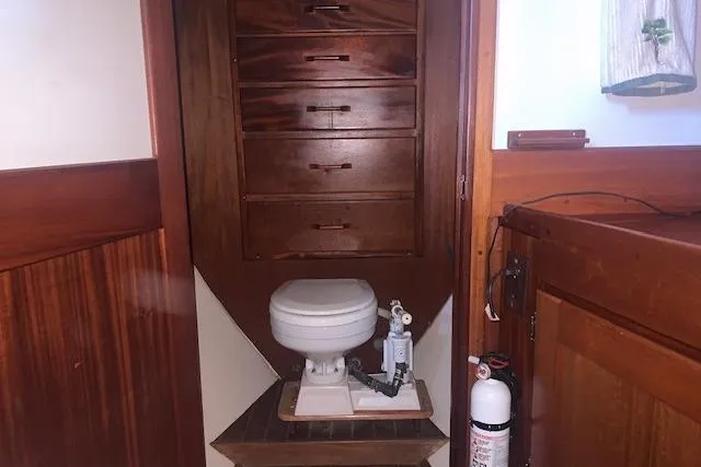 Slide: The Image of 1986 Pilgrim 40 boat interior with wooden cabinetry and marine toilet. - 40