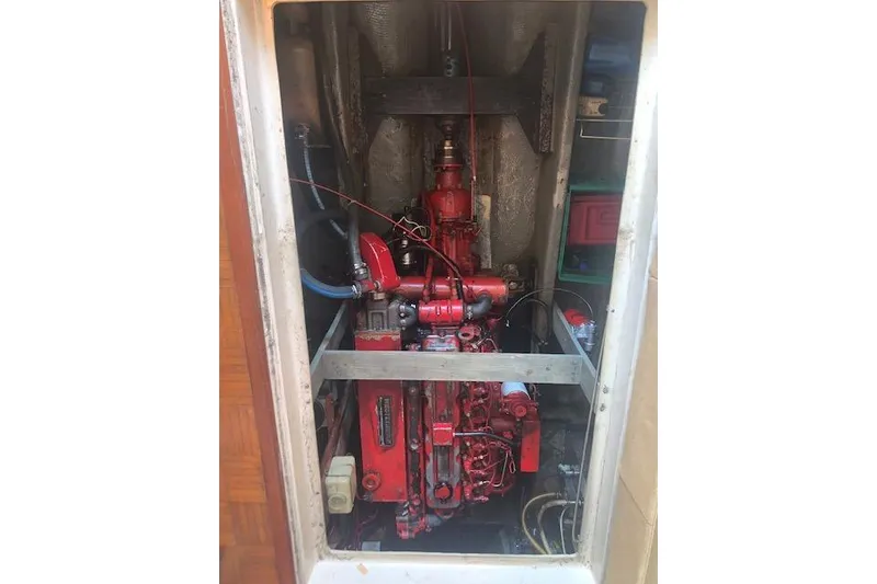 Slide: The Image of Engine compartment of a 1986 Pilgrim 40 boat, featuring a red engine. - 42