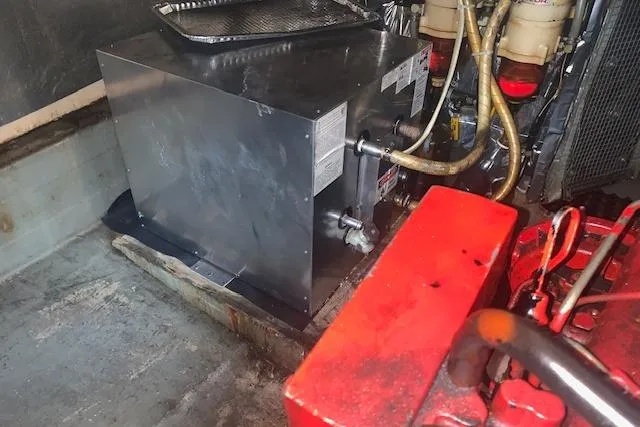Slide: The Image of Engine compartment of a 1986 Pilgrim 40 boat, featuring metal components and hoses. - 43