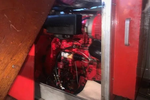 Slide: The Image of Engine compartment of a 1986 Pilgrim 40, showcasing red mechanical components and wiring. - 44