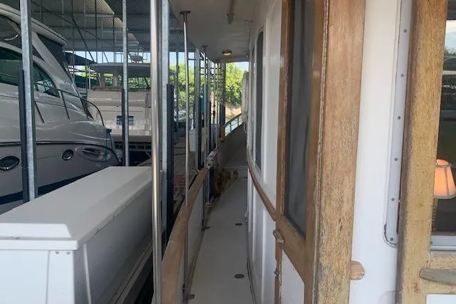 Slide: The Image of 1986 Pilgrim 40 boat docked, showing narrow side deck and wooden door. - 6