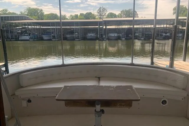 Slide: The Image of 1986 Pilgrim 40 boat interior with seating and table, docked at a marina. - 8
