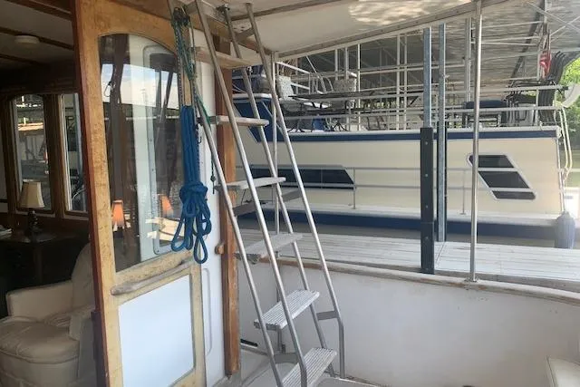 Slide: The Image of 1986 Pilgrim 40 boat interior with ladder and docked vessel in background. - 9